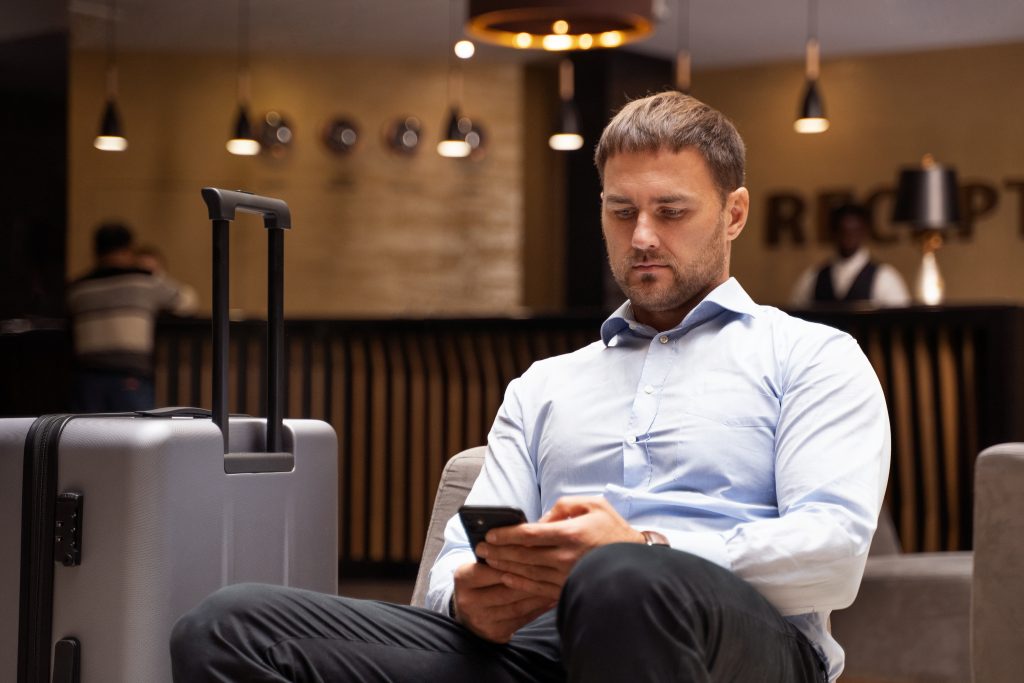 Man holding a smartphone in hotel reception